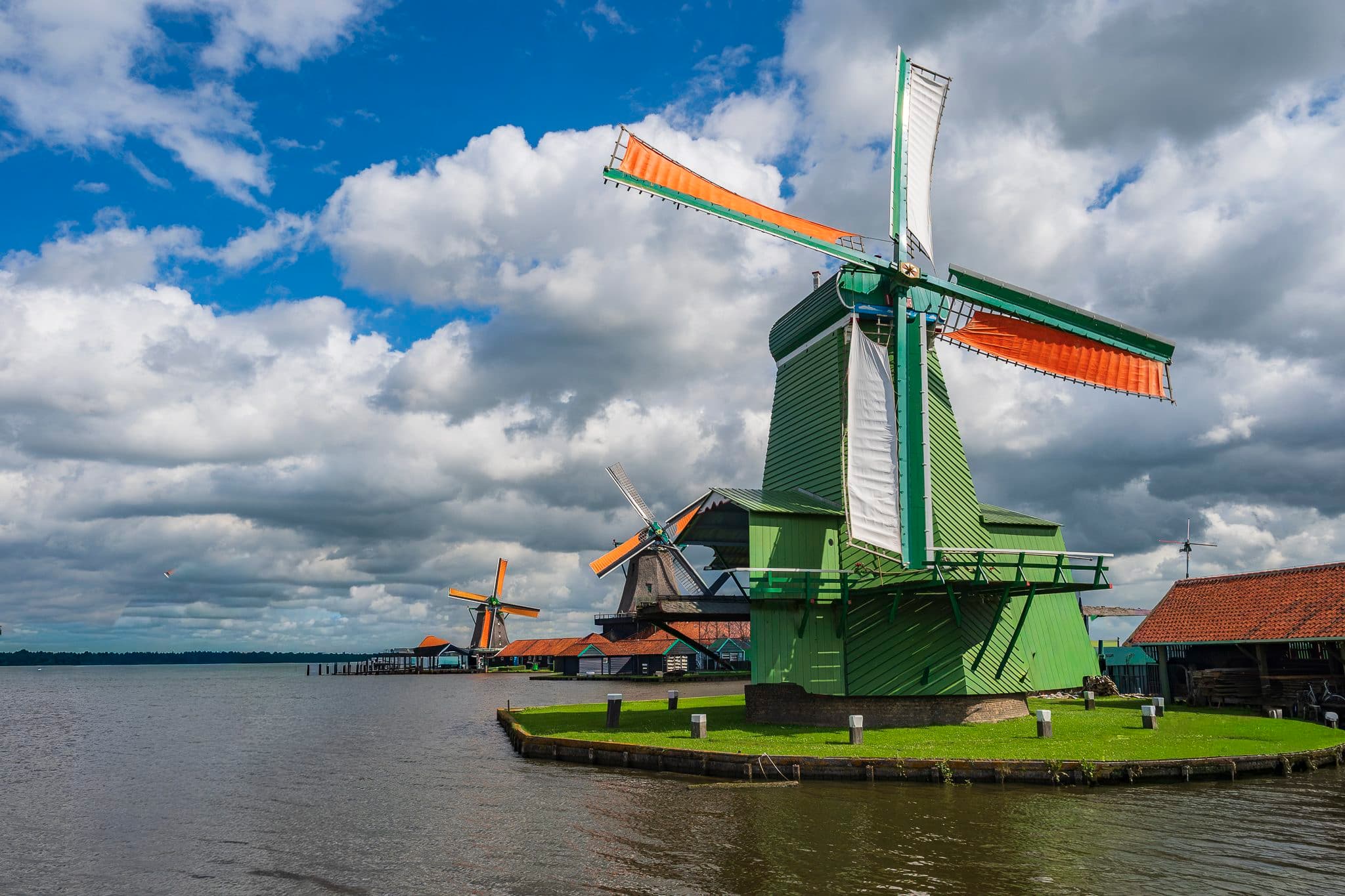 Green windmill at Zaanse Schans by the Zaan river, Netherlands