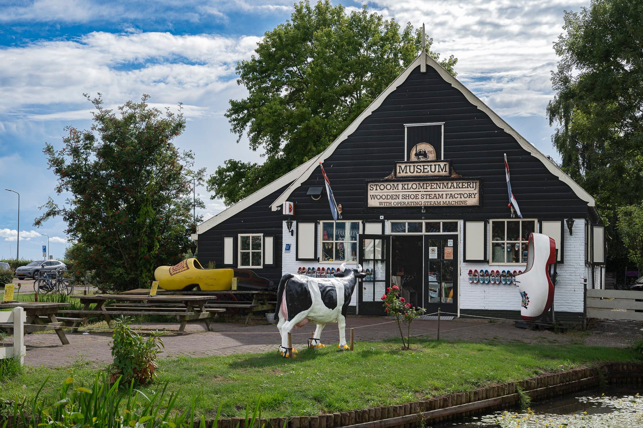 Marken wooden shoe steam factory, a wooden house with a cow statue at the entrance